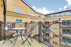 a balcony with a table and chairs in front of a building at 2&3 Bedrooms near EXCEL London - Modern Spacious Apartment For Larger Groups in London