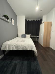 Ensuite room in West Midlands في Parkside: غرفة نوم بسرير ولحاف ابيض