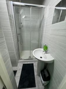 Ensuite room in West Midlands في Parkside: حمام أبيض مع دش ومغسلة