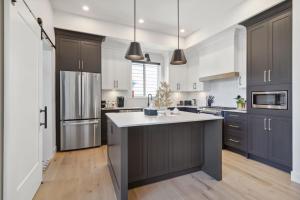 a kitchen with gray cabinets and a large island at Glamorous, Luxurious & Stylish Family Home, Near Vancouver in Langley