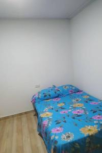 1 cama con edredón azul en una habitación en Acogedor apartamento en el salado, en Ibagué