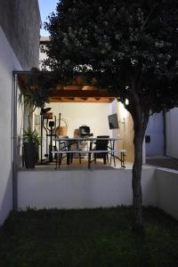 a table and chairs on a patio with a tree at JM Alojamento local no Porto in Porto