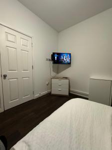 a bedroom with a bed and a tv on a wall at Ensuite room in West Midlands in Parkside