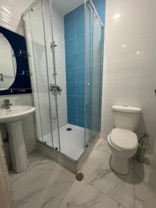 ein Bad mit einer Dusche, einem WC und einem Waschbecken in der Unterkunft Hotel Principal in Tarrafal