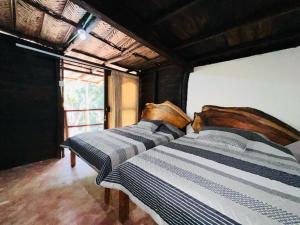 two twin beds in a room with a window at Cabaña Minca sierra nevada in Santa Marta