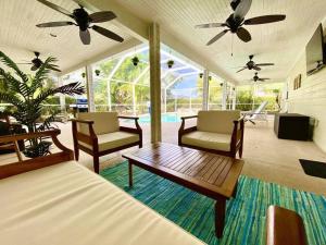 ein Wohnzimmer mit 2 Stühlen und einem Couchtisch in der Unterkunft Hidden Gem: Escape to Newlin Cottage in Cape Coral in Cape Coral