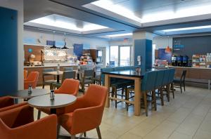 a restaurant with tables and chairs and a counter at Holiday Inn Express Kamloops, an IHG Hotel in Kamloops