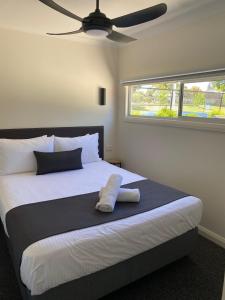 a bedroom with a large bed with a pillow on it at Corowa Bindaree Holiday Park in Corowa