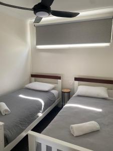 2 Betten in einem Zimmer mit Deckenventilator in der Unterkunft Corowa Bindaree Holiday Park in Corowa