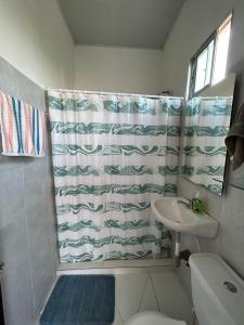 La salle de bains est pourvue d'un rideau de douche et d'un lavabo. dans l'établissement Amberes, à Puerto Colombia