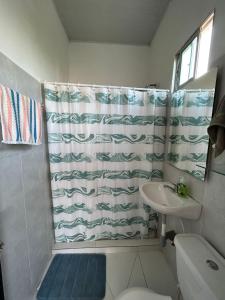 a bathroom with a shower curtain and a sink at Amiri in Puerto Colombia