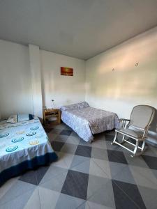 Cette chambre comprend 2 lits et une chaise. dans l'établissement Amberes, à Puerto Colombia