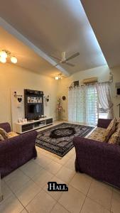 een woonkamer met 2 banken en een flatscreen-tv bij Eehome in Ipoh