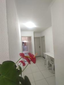 uma sala de estar com uma mesa e uma flor vermelha em Residência RCA13 em Santos