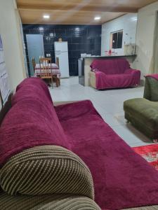 a living room with a purple couch in the middle at Cantinho da Vânia in Cabo Frio