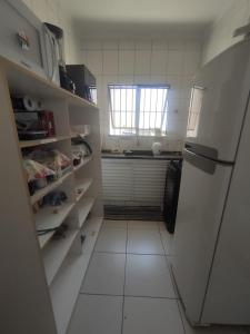 a kitchen with a refrigerator and a white tiled floor at Residência RCA13 in Santos