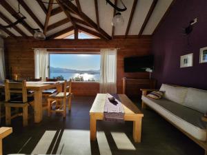 un soggiorno con divano e tavolo di Punta Negra a Villa Pehuenia