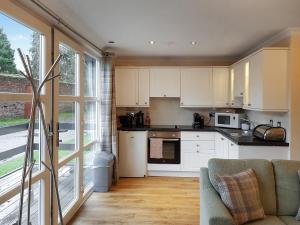 a kitchen with white cabinets and a large window at Leven Lodge 2 - Uk46044 in Balloch
