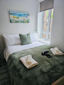 a bedroom with a bed with towels and a window at Lovely Double Rooms in Euston & Square in London