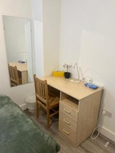 Schlafzimmer mit einem Schreibtisch, einem Spiegel und einem Bett in der Unterkunft Lovely Double Rooms in Euston & Square in London