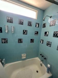 a bathroom with a tub and a blue tiled wall at CorrientesNice in Buenos Aires +24 photos