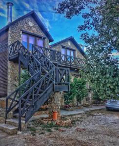 a house with a wooden walkway in front of it at Anilia Guesthouse in Synikia Mesi Trikalon