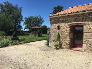 a stone building with a gazebo in a yard at Gîte charmant à la campagne avec terrasse, proche du Puy du Fou et de la rivière Sèvre - FR-1-426-249 in Sevremont