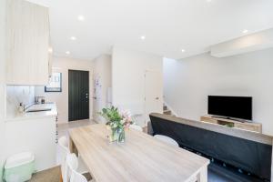 a kitchen and dining room with a table and chairs at Cozy Brand New Townhouse 16 in Auckland