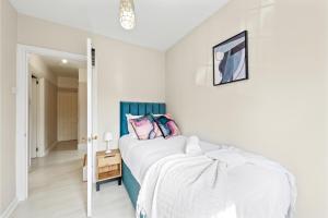 a white bedroom with a bed and a mirror at Huge Home by Station / Gym & Garden in London