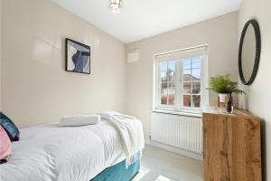 um quarto com uma cama e uma janela em Huge Home by Station / Gym & Garden em Londres