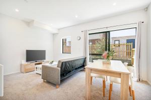 a living room with a couch and a table at Cozy Brand New Townhouse 20 in Auckland