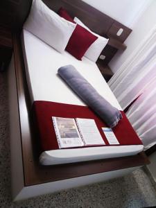 una cama con una almohada y un libro sobre ella en Hotel Bicentenario Rionegro, en Rionegro