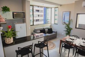a living room with a table and chairs and a couch at Edf. Mar dos corais - a poucos passos do mar in Maceió