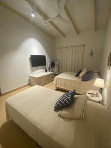 a hotel room with two beds and a tv at La Escondida Samber in San Bernardino