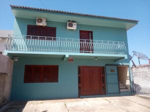 una casa azul con balcón en la parte superior en La posada en São Gabriel