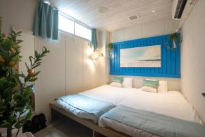 sypialnia z dużym łóżkiem z niebieskim zagłówkiem w obiekcie Glamping Tokyo Asakusa w Tokio