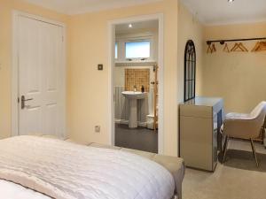 a bedroom with a bed and a bathroom with a sink at Leven Lodge 1 - Uk46042 in Balloch