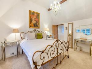 a bedroom with a bed and two tables and a chandelier at The Cottage in Hungerton