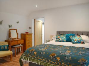 a bedroom with a bed and a dresser and a mirror at Swallow Lodge in Horsington