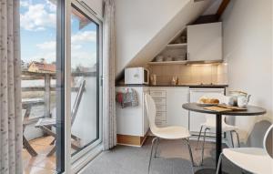 a small kitchen with a table and chairs and a balcony at Amazing Apartment In Allinge With Kitchen in Sandvig