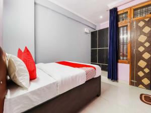 a bedroom with a bed with red pillows at OYO Flagship Kalawati Palace in Bhauli