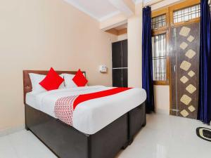 1 dormitorio con 1 cama grande con almohadas rojas en OYO Flagship Kalawati Palace en Bhauli