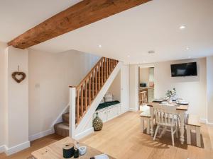 Marchamley的住宿－Northwood Farm Cottage，厨房以及带楼梯和桌子的客厅。