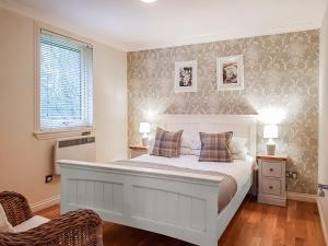 a bedroom with a large white bed with two pillows at Leven Lodge 3 - Uk46045 in Balloch