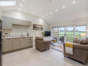 a kitchen and living room with a couch and chairs at Mabels Stable in Clitheroe