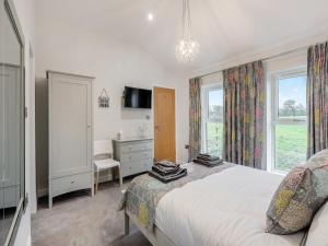 a bedroom with a bed and a desk and window at Mabels Stable in Clitheroe