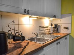 una cucina con lavandino e piano di lavoro di Dormys Cottage a Skegness