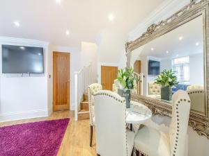 a dining room with a mirror and a purple rug at Violet Cottage - Uk45968 in Yarm