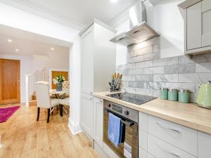 a kitchen with white cabinets and a counter top at Violet Cottage - Uk45968 in Yarm
