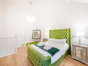Schlafzimmer mit einem grünen Kopfteil und einem Bett in der Unterkunft Violet Cottage - Uk45968 in Yarm